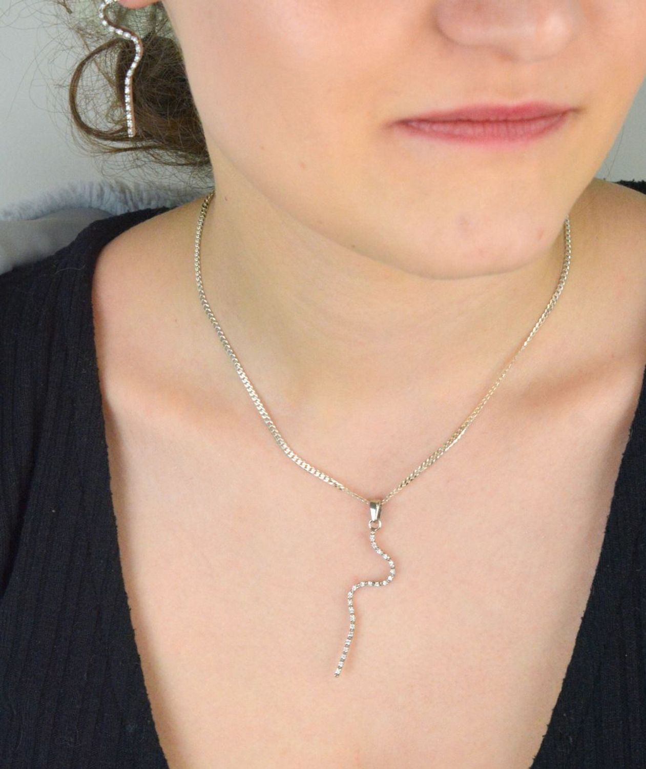 Zawieszka damska W 1580 wykonana ze srebra próby 925. Długość 5,5 cm, zdobiona drobną cyrkonią o szerokości 1 mm, waga 1,91 g. Smukła, elegancka biżuteria na każdą okazję.1.jpg